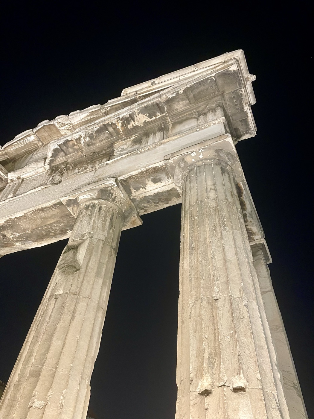 Ancient marble columns lit up against the night sky in Athens