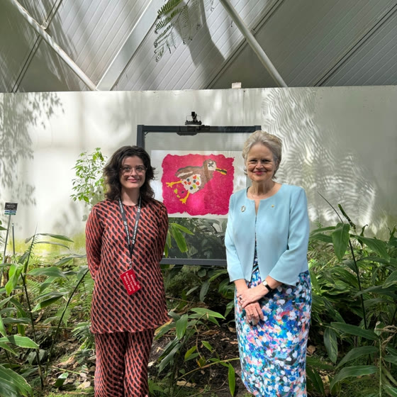 Lia with a guest in front of an exhibited artwork