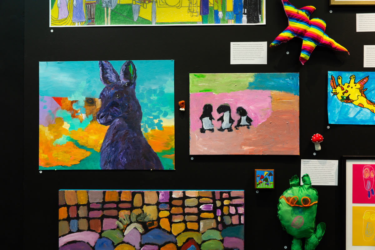 Salon hang of paintings including a blue rabbit