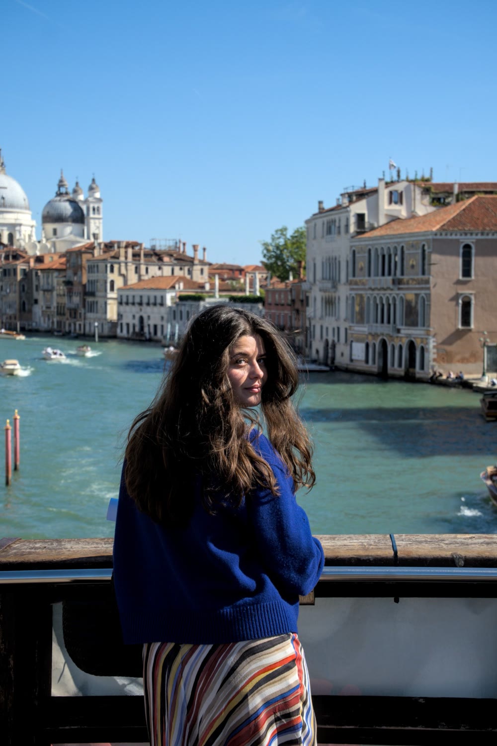 Lia Karabatsos looking back over her shoulder on a bridge above the Grand Canal, Venice